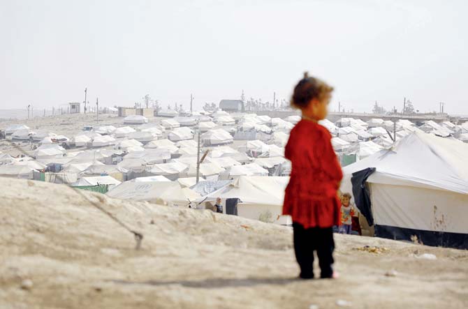 An Iraqi refugee who fled Mosul stands between tents at the UN-run Al-Hol refugee camp in Syria’s Hasakeh province. Pic/AFP