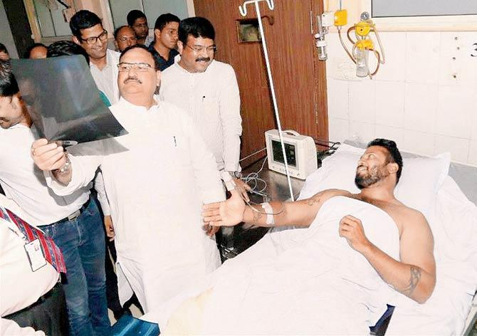 Union Health Minister J P Nadda sees the X-Ray of a patient rescued from the fire. Pic/PTI