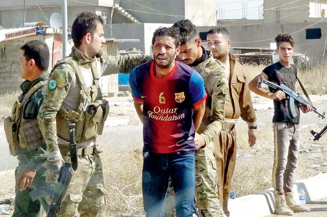 Kurdish security forces detain a suspected IS member. Pic/AFP