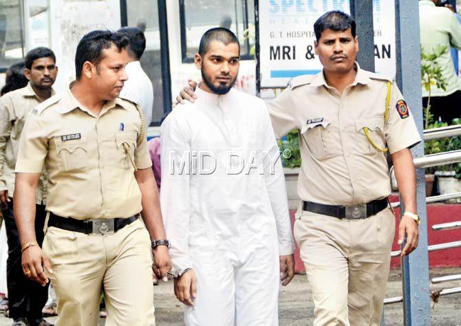 Mumbra resident Mustafa Mansoor Valele (22) in custody of the Azad Maidan police after officers managed to overpower him when he was raging about on Fashion Street with a hammer. Pics/Bipin Kokate