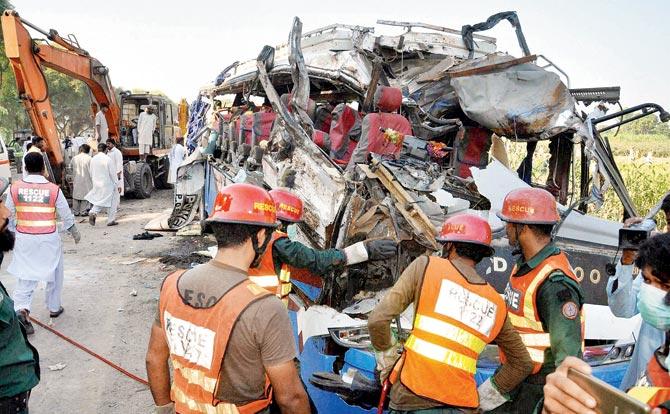 A Pakistani rescue team work on the wreckage of an accident involving two buses in Khanpur. Pic/AP/PTI