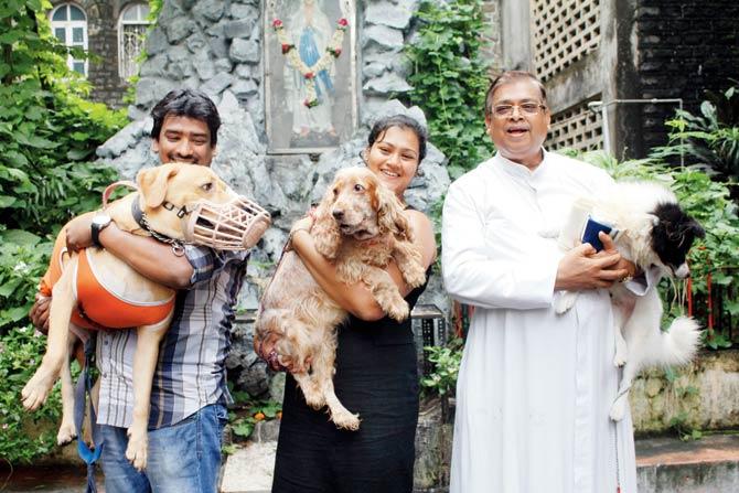 Owners and their pets at a earlier blessing of pets ceremony, with Fr Joe D’Souza