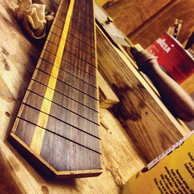 A fretboard featuring three different types of wood — jackfruit stripe and teak-bound rosewood