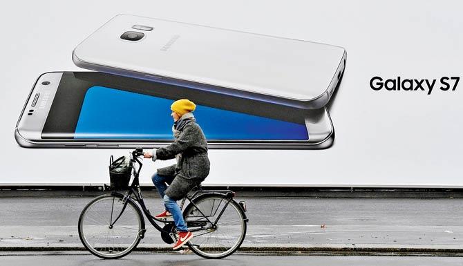 A woman cycles past a billboard advertising Samsung’s Galaxy S7 Edge smartphone on Tuesday in Berlin. Pic/AFP