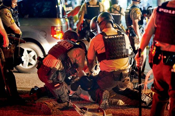 File photo of police detaining a man during a civil disobedience march in Ferguson, Missouri last year. Pic/AFP