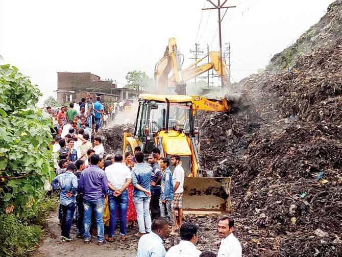 Locals gathered at the Ulhasnagar dumping ground on Sunday while others searched the ground for two children allegedly stuck under the garbage