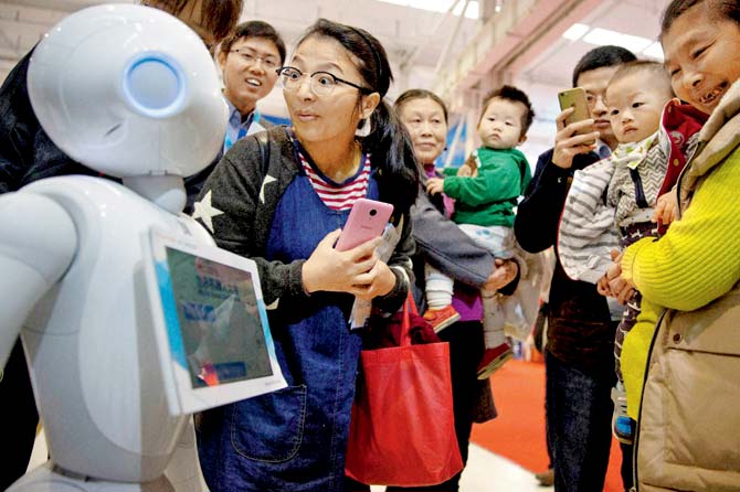Visitors take a closer look at Pepper, a companion robot, at the World Robot Conference in China, which is now focused on high-end technology. Pic/AP
