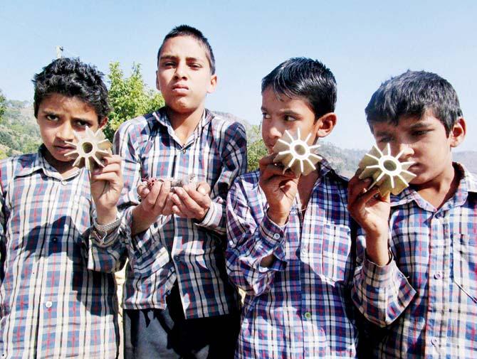 Children from a bordering village in Rajouri district show parts of mortar shells fired from across the LoC by Pakistan. Pic/PTI