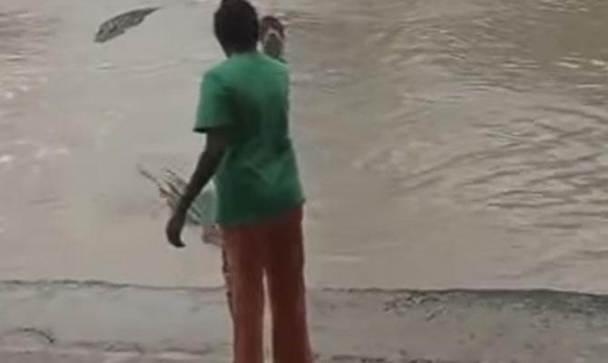 Videograb of the incident showing the woman warding off the crocodile