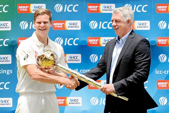 Australia’s cricket captain Steven Smith (left) receives the International Cricket Council Test Championship mace from ICC chief executive David Richardson in Kandy last July. PIC/AFP