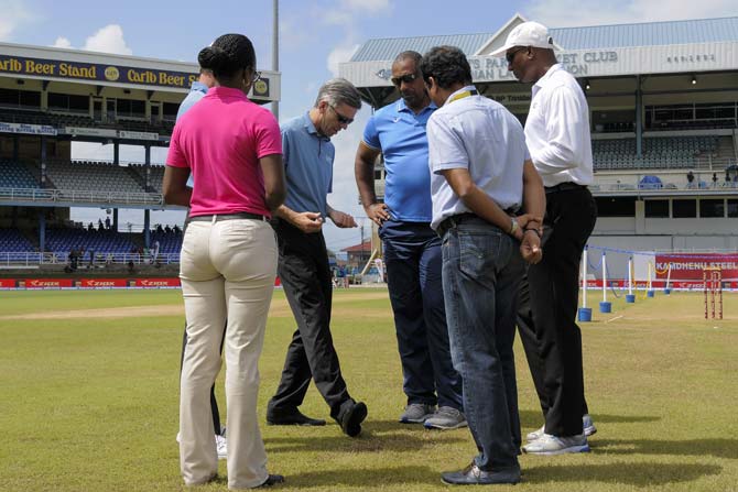 Match officials inspect the field during day 4 of the 4th and final Test between West Indies and India at Queen
