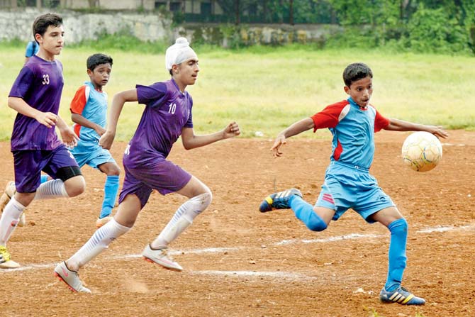 Don Bosco’s Shyam Redekar (extreme right) scores the only goal of the match in the final of the DSO U-14 inter-school football against Cathderal & John Connon at Worli Sports Club ground yesterday. 