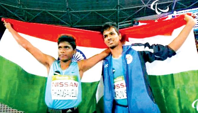 Indian Paralympic medallist Mariyappan Thangavelu (left) and Varun Singh Bhati pose with the national flag on Friday. Pic/PTI