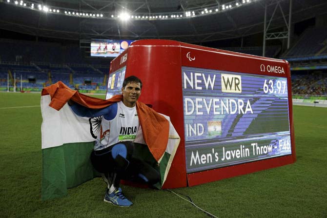 Devendra Jhajharia poses for the pictures next to the scoreboard that shows his world record in the men