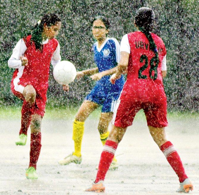 Anagha Janakkiraman of Arya Vidya Mandir (right) takes control of the ball as Charul Maheshka of Dhirubhai Ambani (blue) and Urvashi Maheshwari look on during the Mumbai School Sports Association inter-school girls under-16 Division I match at Azad Maidan yesterday. Pic/Shadab Khan