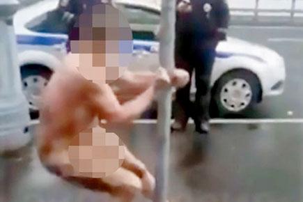 This video of naked man doing 'pole dance' on street is truly bizarre!