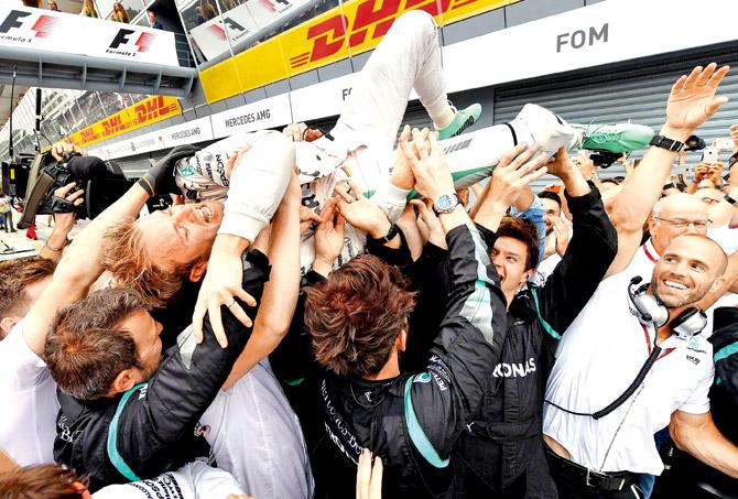 Mercedes driver Nico Rosberg (top) celebrates his Italian Grand Prix victory with his crew at Monza in Italy yesterday. Pic/AFP