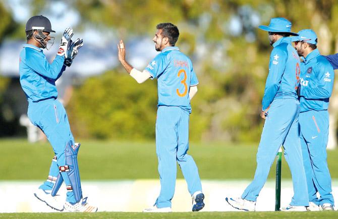 Leggie Yuzvendra Chahal (right) celebrates the wicket of Australian Kane Richardson with wicketkeeper Sanju Samson yesterday