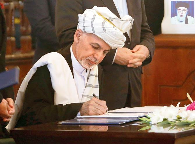 Afghan President Ashraf Ghani signs a peace agreement at the presidential palace in Kabul, while Hekmatyar signed it via a live videoconference that was also televised. Pic/AP