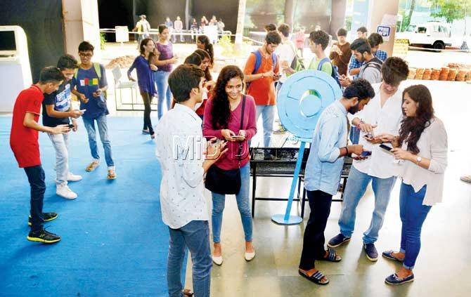 Students gather as they hunt for a catch at one of the Pokestops at Atharva College. Pic/Sneha Kharabe