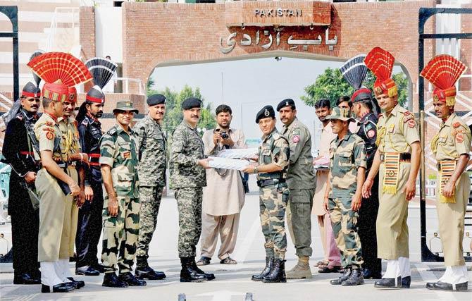 BSF Commandant Sudeep (R) exchanges sweets with Pakistan Rangers Wing Commander Bilal on the occasion of Eid at Attari