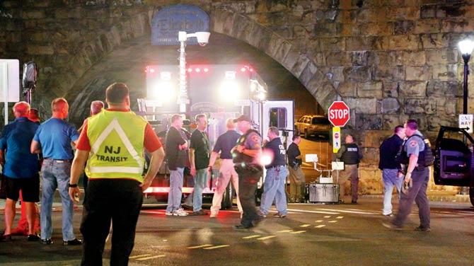 Bomb squad personnel stand around the scene of an explosion near the train station on Monday. Pic/AP