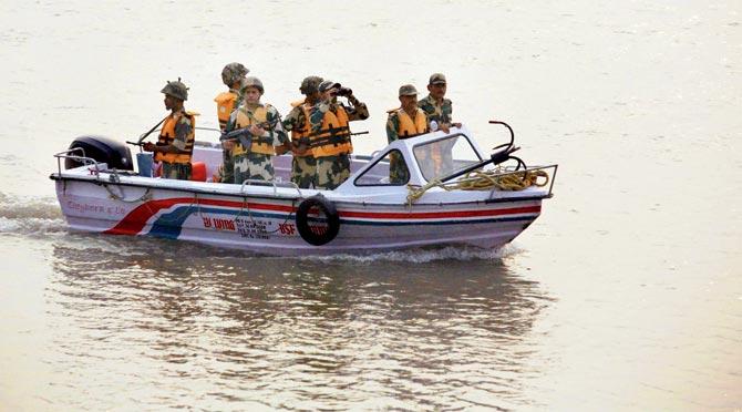 Border Security Force soldiers patrol in the Chenab river near the India-Pakistan border. Pics/PTI,AFP