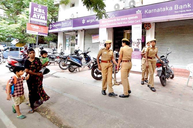Security outside a Karnataka Bank branch in Chennai on Monday in the wake of protests  against the release of water from the river Cauvery. Pic/AP, PTI