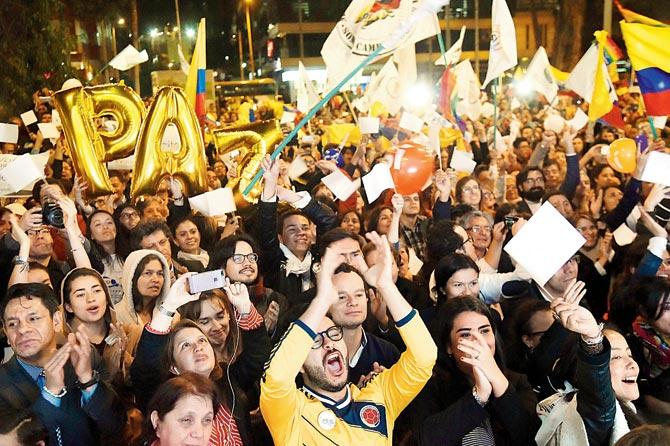 Colombians hold signs reading ‘Peace is my, your, our business. Pic/AFP