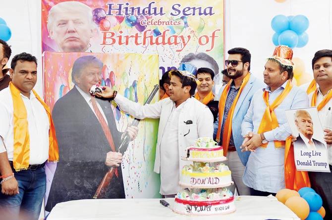 Members of the right-wing Hindu Sena feed cake to a poster of Donald Trump to mark the 70th birthday of the US presidential candidate in New Delhi. Pic/AFP