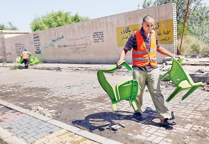 Iraqi municipality workers clean the scene in Baghdad. Pic/AP