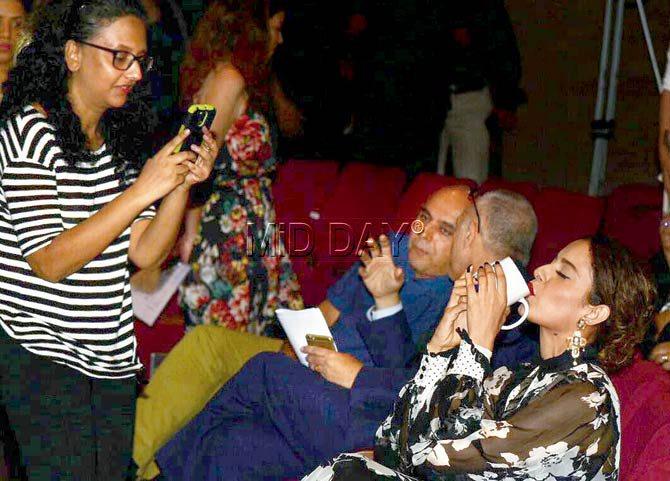 Kangana Ranaut seems content drinking from a cup, and is oblivious to a fan who’s captured her in this candid moment at the press conference last evening. Pic/Shadab Khan