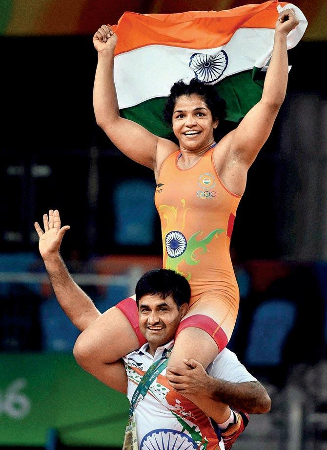 Sakshi Malik’s coach Kuldeep Singh carries her on his shoulder after her bronze medal win in Rio. Pic/PTI