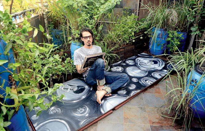 Ramon B (GarabatoArte) sits atop a wooden mural he created for landscapist Gautam Muralidharan’s terrace garden in Versova. He used a mix of acrylic, oil and watercolours for the creative flooring for terrace parties. Pic/Satej Shinde