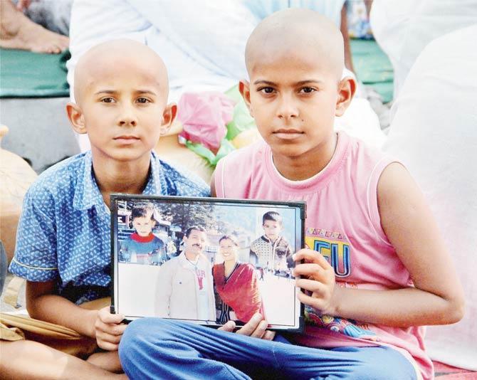 Havildar Ravi Paul Salotra’s sons hold up his photo