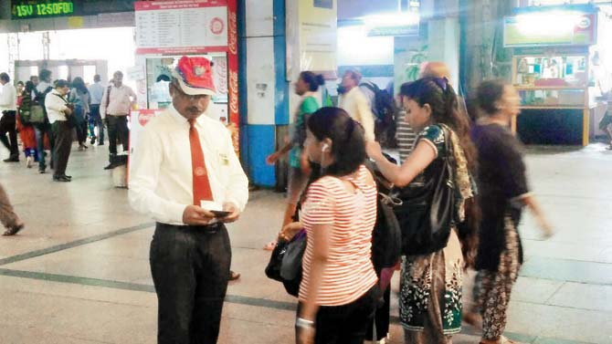 A ticket collector stops commuters at Churchgate station for littering