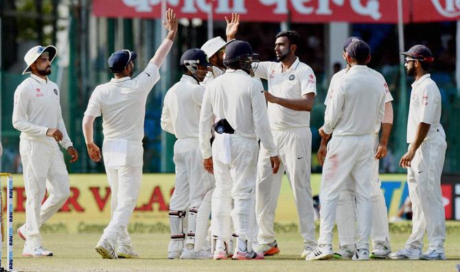 Ravichandran Ashwin with teammates celebrates a wicket 