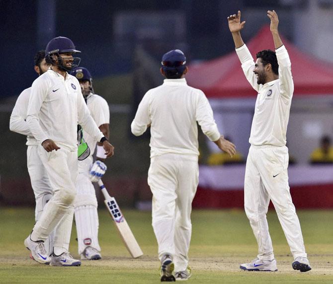 India Blue bowler R Jadeja (R) celebrates the dismissal of India Red batsman Stuart Binny on 98 runs during third day