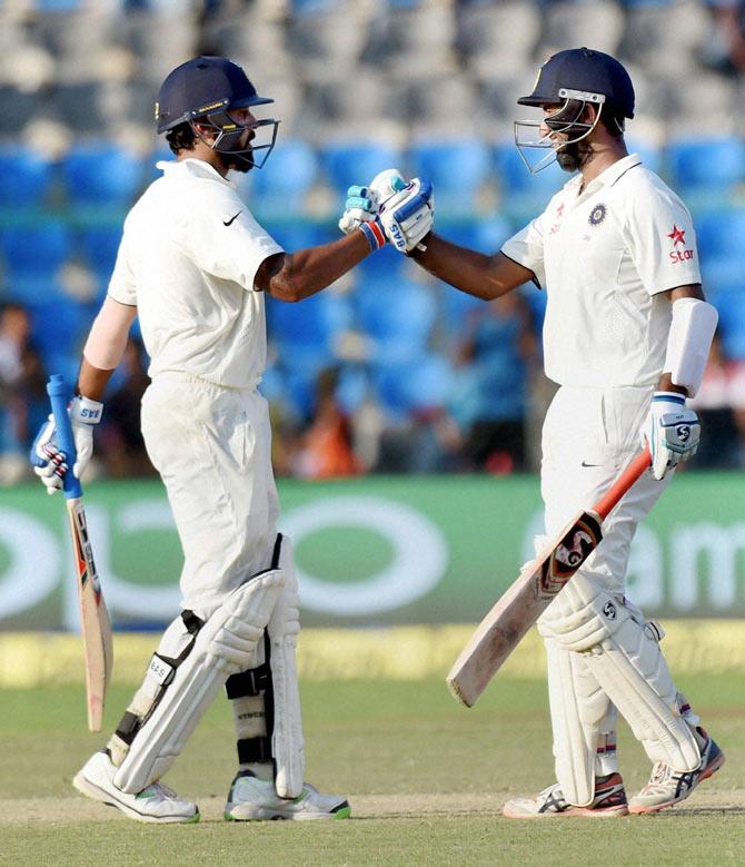 Murali Vijay congratulates Cheteshwar Pujara after the latter completed his half-century against New Zealand in India