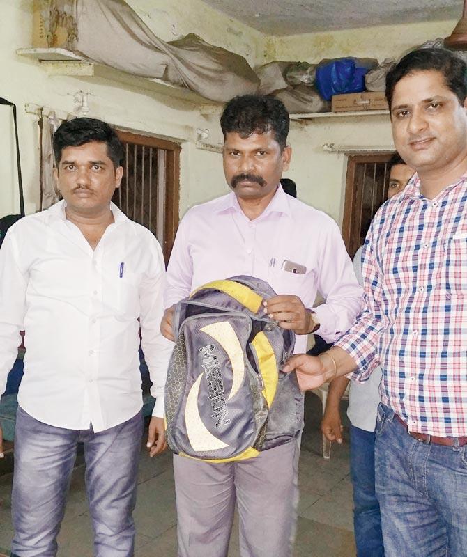 Bandra GRP officers, including investigating officer API Navanath Rupwate (centre), show the recovered bag