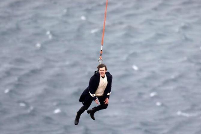Harry Styles hangs from a helicopter for 