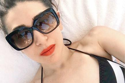 Karisma Kapoor beats the heat in monochrome swimwear, flaming red lips