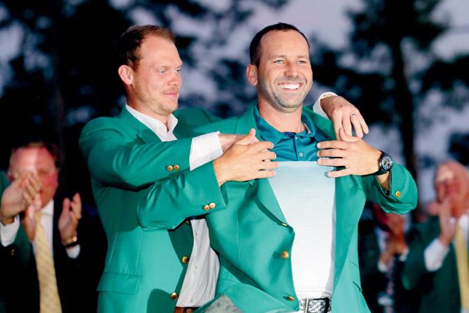 England’s Danny Willett (left) presents Spain’s Sergio Garcia with the green jacket at the Augusta Masters on Sunday. Pic/AFP
