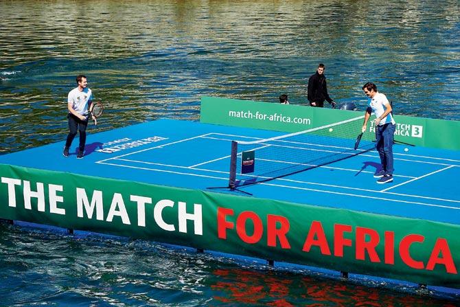 Swiss tennis superstar Roger Federer (right) returns to Britain’s Andy Murray during a training session on a raft on the Limmat river ahead of a charity match in Zurich, Switzerland yesterday. Pic/AFP