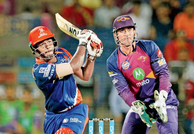 Delhi Daredevils’ Sanju Samson hits one over the top as Rising Pune Supergiant’s ’keeper MS Dhoni looks on during the IPLâu00c2u0080u00c2u0088game at the Maharashtra Cricket Association Stadium in Pune yesterday. Pic/AFP