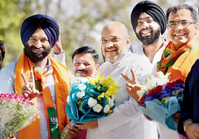 BJP President Amit Shah greets BJP-Shiromani Akali Dal (SAD) joint candidate Manjinder Singh Sirsa after his victory in the Rajouri Garden bypoll. Pic/PTI