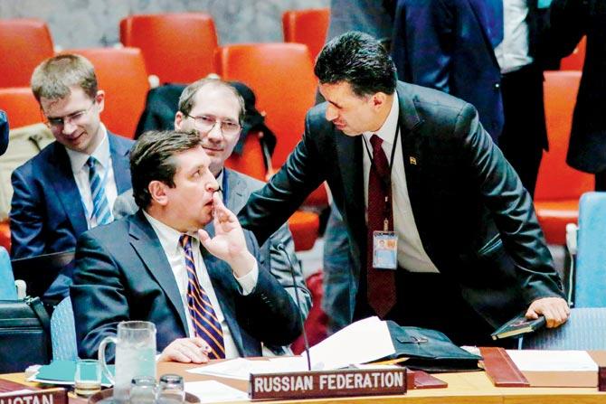 Russian Deputy Permanent Representative to the UN Vladimir Safronkov (L) speaks with Bolivia’s ambassador before a voteq