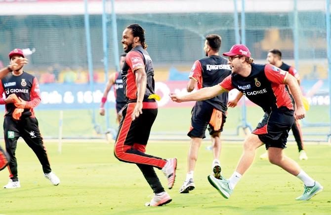 Royal Challengers Bangalore’s Chris Gayle (left) and coach Daniel Vettori during a cheerful practice session in Bangalore yesterday. Pic/PTI 
