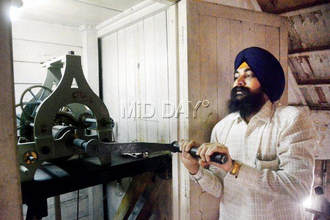 Mahinder Singh leans out to clean the frames of the 129-year-old CST clock tower. Pics/Bipin Kokate