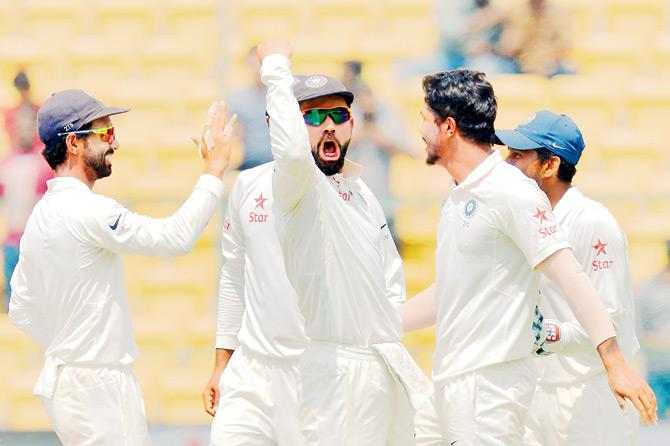 India captain Virat Kohli (centre) leads the celebration after Umesh Yadav (right) dismissed Australia captain Steven Smith during Day Four of the second Test in Bangalore on March 7, 2017. Pic/AFP